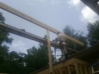 Carpenter setting a ridge beam over a new addition frame — Ice Dam Removal by Roofing Brothers in East Peoria