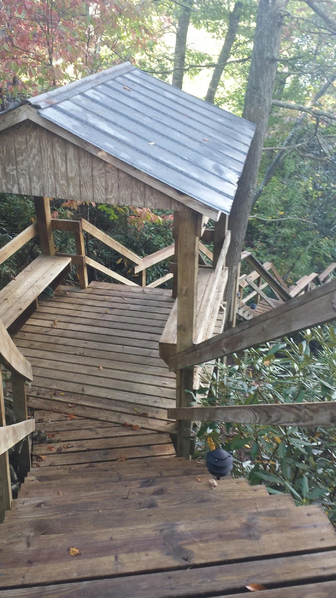 Metal roofed shelter over wooden steps on a wooded walkway — Skylight Repair & Installation work by our crew in East Peoria