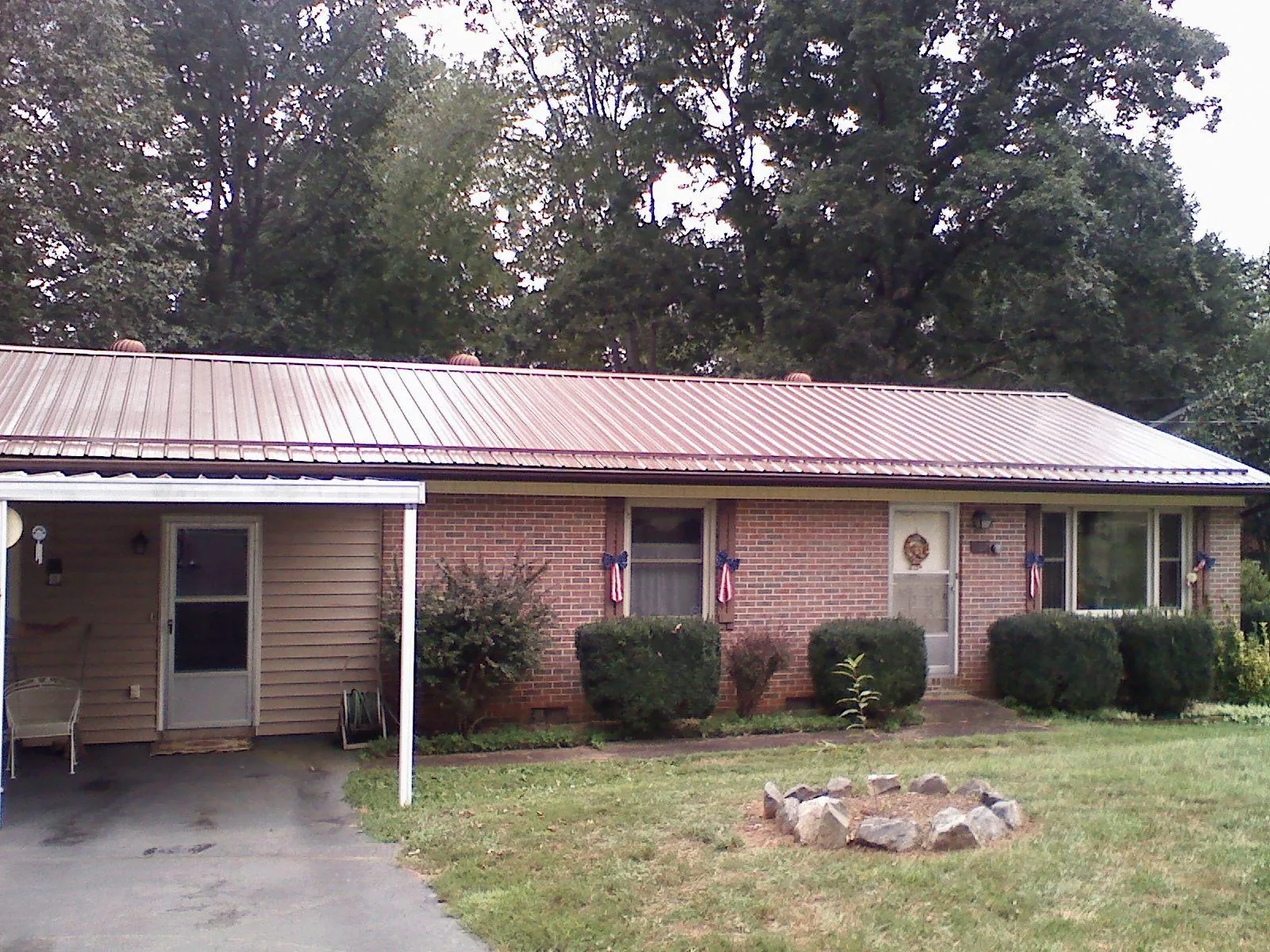 Bronze metal roof and carport on a brick ranch home — Roof Repair work by our crew in East Peoria